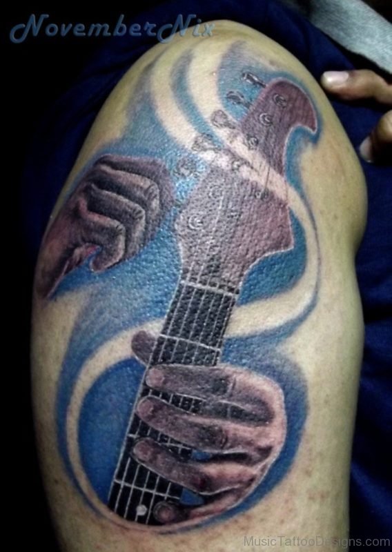 Hand Holding Guitar Tattoo On Shoulder For Men